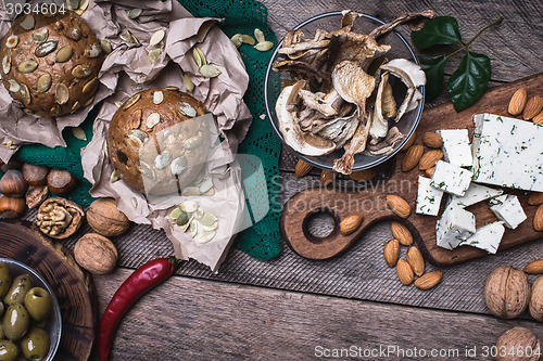 Image of rustic style cheese with bread, cep, olives and nuts