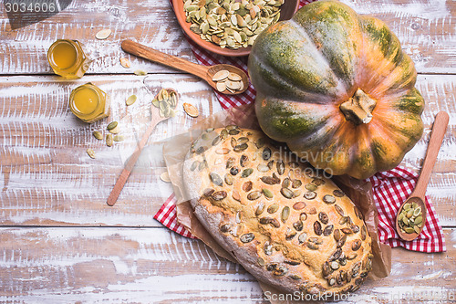 Image of Bread with seeds and pumpkin on wooden table in rustic style