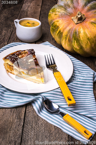 Image of Pumpkin pie piece with cream soup on wood in Rustic style