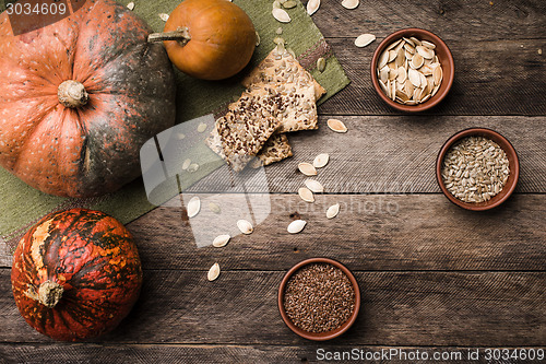 Image of Rustic pumpkins with cookies and seeds on wood 