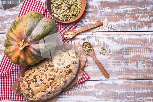 Image of White bread with pumpkin seeds on wooden table