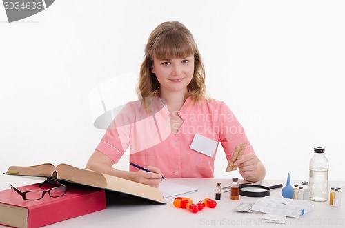 Image of Pharmacist with a pack of pills in package