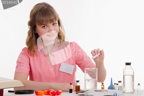 Image of Pharmacy pours the powder into a flask with liquid