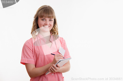 Image of Medical practice writing in a notebook