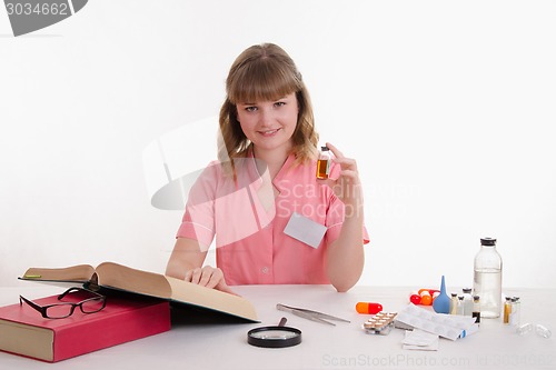 Image of Pharmacist with an ampoule and reference