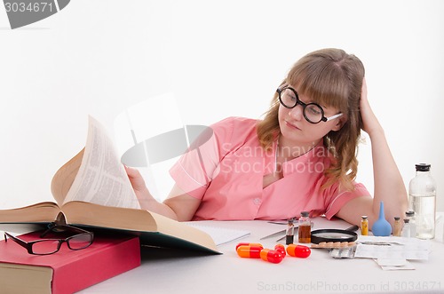 Image of Tired student pharmacist flipping book