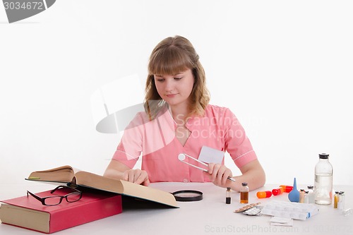 Image of Thoughtful doctor read the description pills