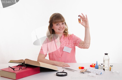 Image of Pharmacist sitting at a table with an ampoule