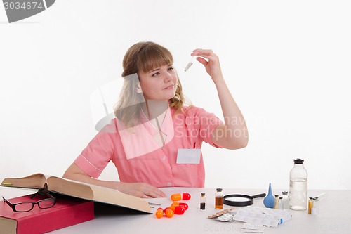 Image of Pharmacist considers powder in a test tube