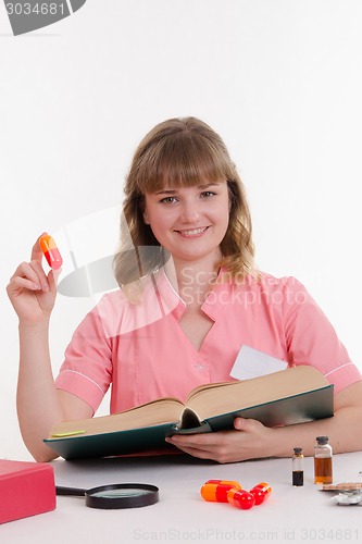 Image of Pharmacist with pill and reference