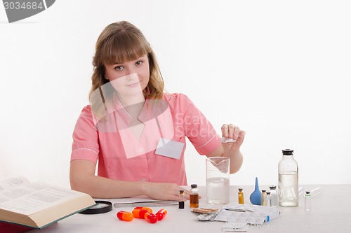Image of Pours pharmacist prepares the medication