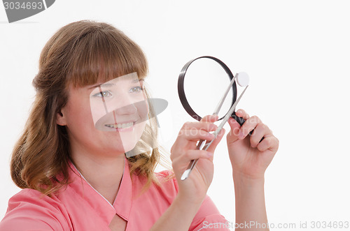 Image of Pharmacist closely examines tablet under a magnifying glass