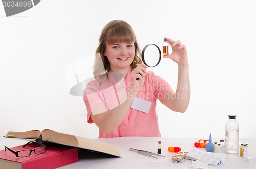 Image of Pharmacist considers liquid medicine