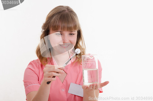 Image of Student pharmacist throws pill to liquid water