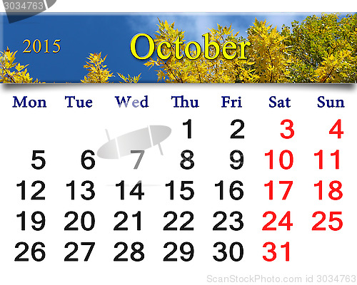 Image of calendar for October of 2015 with autumn leaves and sky