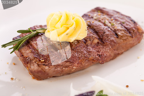 Image of Grilled beef steak topped with butter and rosemary