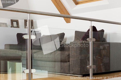 Image of Grey Sofa Behind Metal and Glass Railing