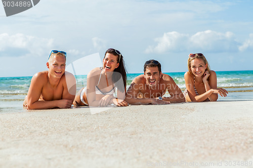 Image of young happy friends havin fun on the beach