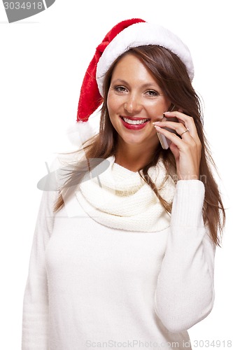 Image of Pretty woman in a Santa hat reading an sms