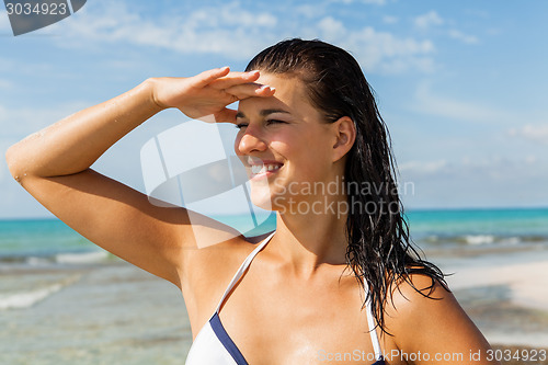 Image of Young woman looking far away in the beach