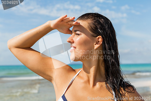 Image of Young woman looking far away in the beach