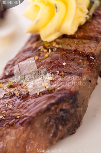 Image of Grilled beef steak topped with butter and rosemary