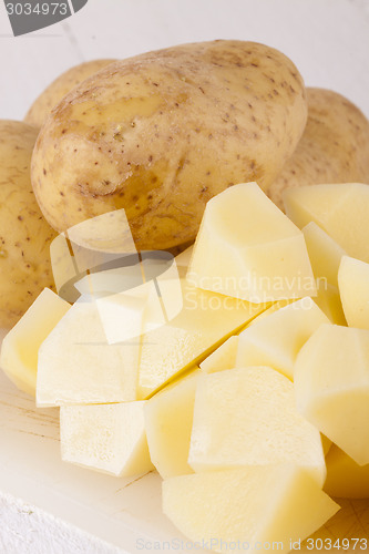 Image of Whole Potatoes and Chopped Pieces on Cutting Board