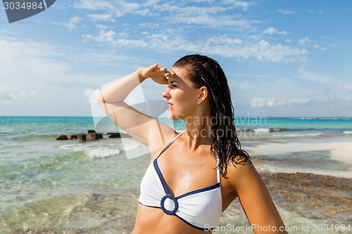 Image of Young woman looking far away in the beach