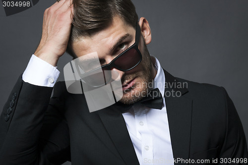 Image of Handsome businessman adjusting his tie