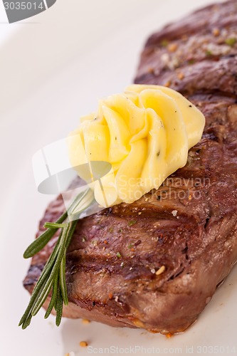 Image of Grilled beef steak topped with butter and rosemary