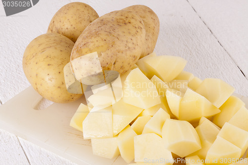 Image of Whole Potatoes and Chopped Pieces on Cutting Board