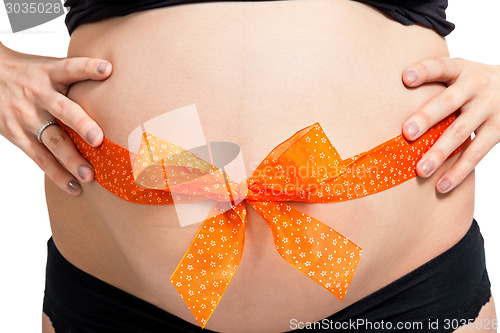 Image of Pregnant woman wearing a bow on her belly