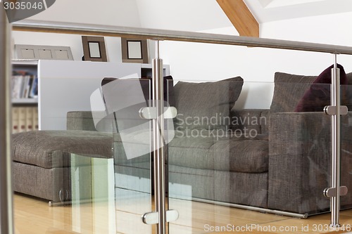 Image of Grey Sofa Behind Metal and Glass Railing