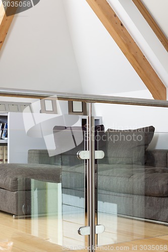 Image of Grey Sofa Behind Metal and Glass Railing