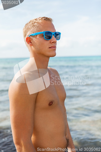 Image of Man in blue swim shorts in the beach