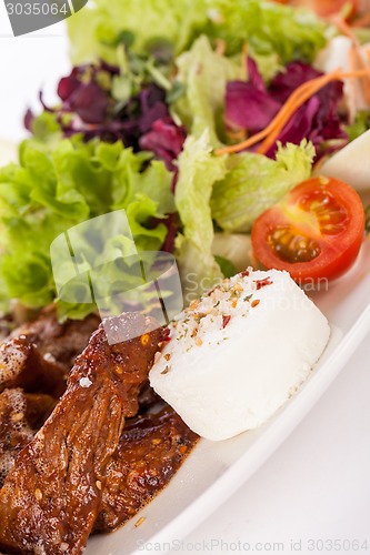 Image of grilled beef stripes fresh salad and goat cheese