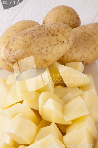 Image of Whole Potatoes and Chopped Pieces on Cutting Board