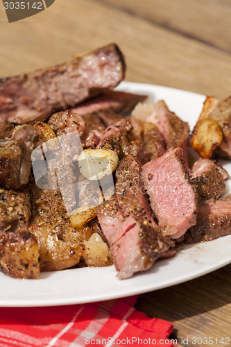 Image of Plate of Grilled Steak and Garlic with Red Napkin