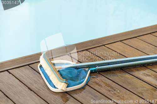 Image of Brush and Leaf Skimmer Beside Swimming Pool