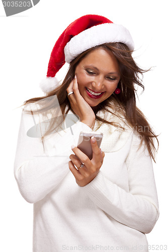 Image of Pretty woman in a Santa hat reading an sms