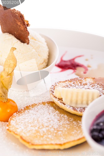 Image of tasty sweet pancakes with vanilla icecream and topping