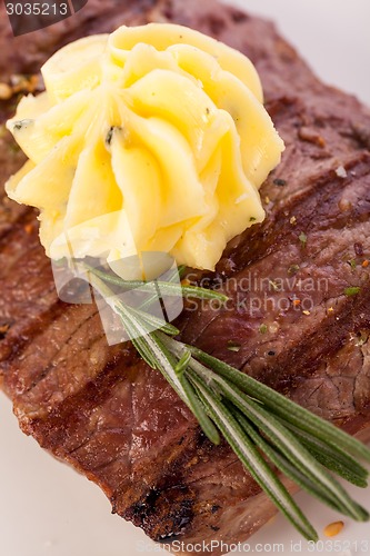 Image of Grilled beef steak topped with butter and rosemary