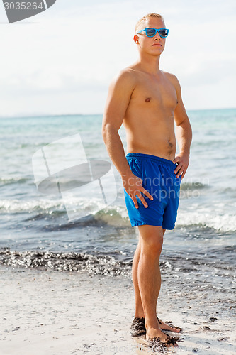 Image of Man in blue swim shorts in the beach