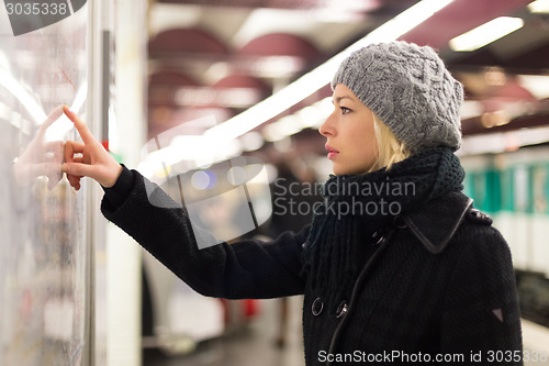 Image of Lady looking on public transport map panel.