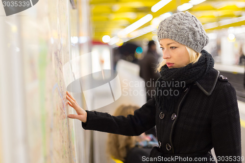 Image of Lady looking on public transport map panel.