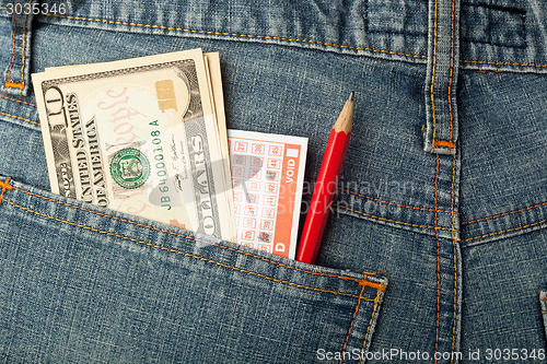 Image of US money and lottery bet slip in pocket