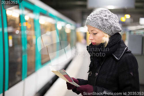 Image of Lady waiting on subway station platform.