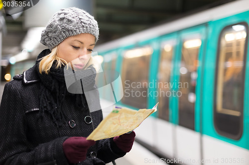 Image of Lady waiting on subway station platform.