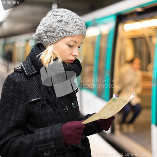 Image of Lady waiting on subway station platform.