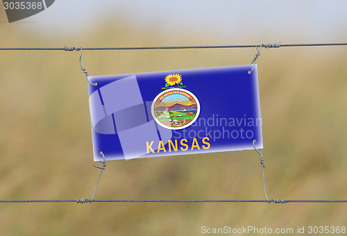 Image of Border fence - Old plastic sign with a flag